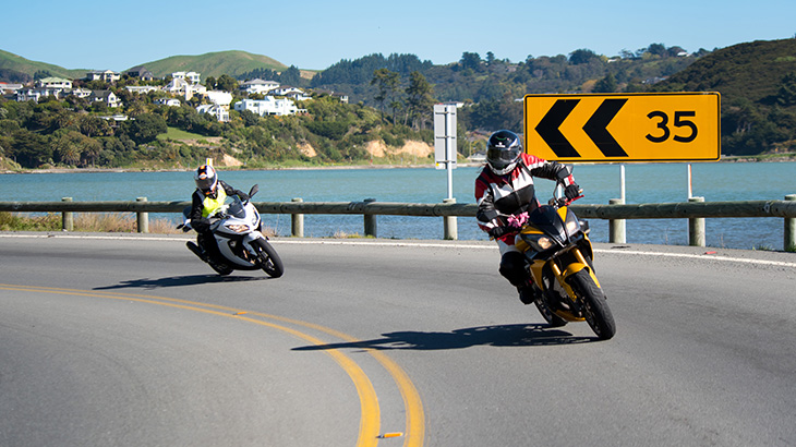 Two motorcyclists take a corner.